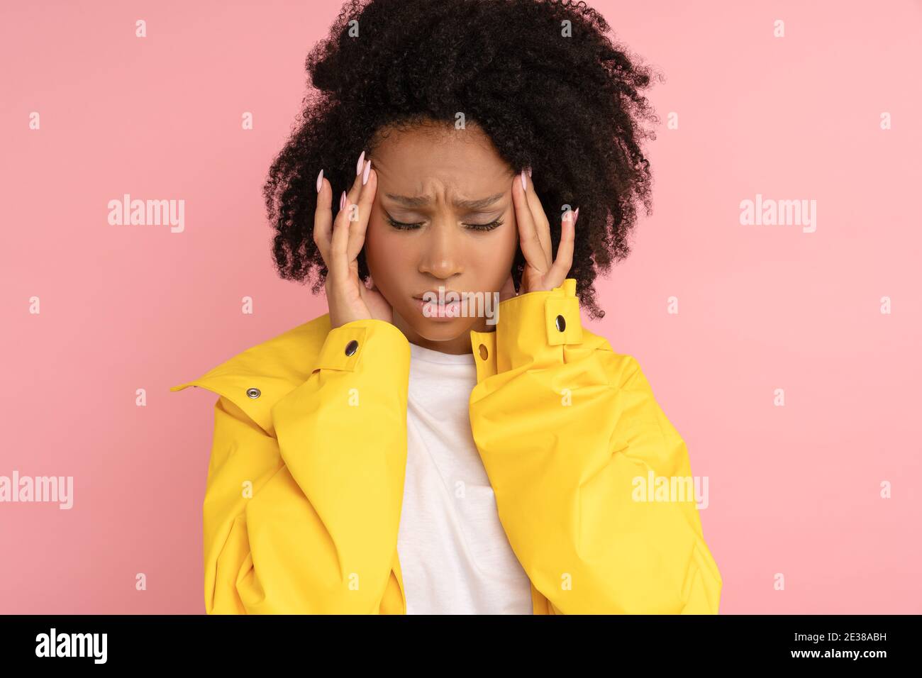 Unhappy Afro Woman Wear Yellow Raincoat Suffers From Severe Throbbing Unhappy Afro Woman Wear Yellow Raincoat Suffers From Severe Throbbing