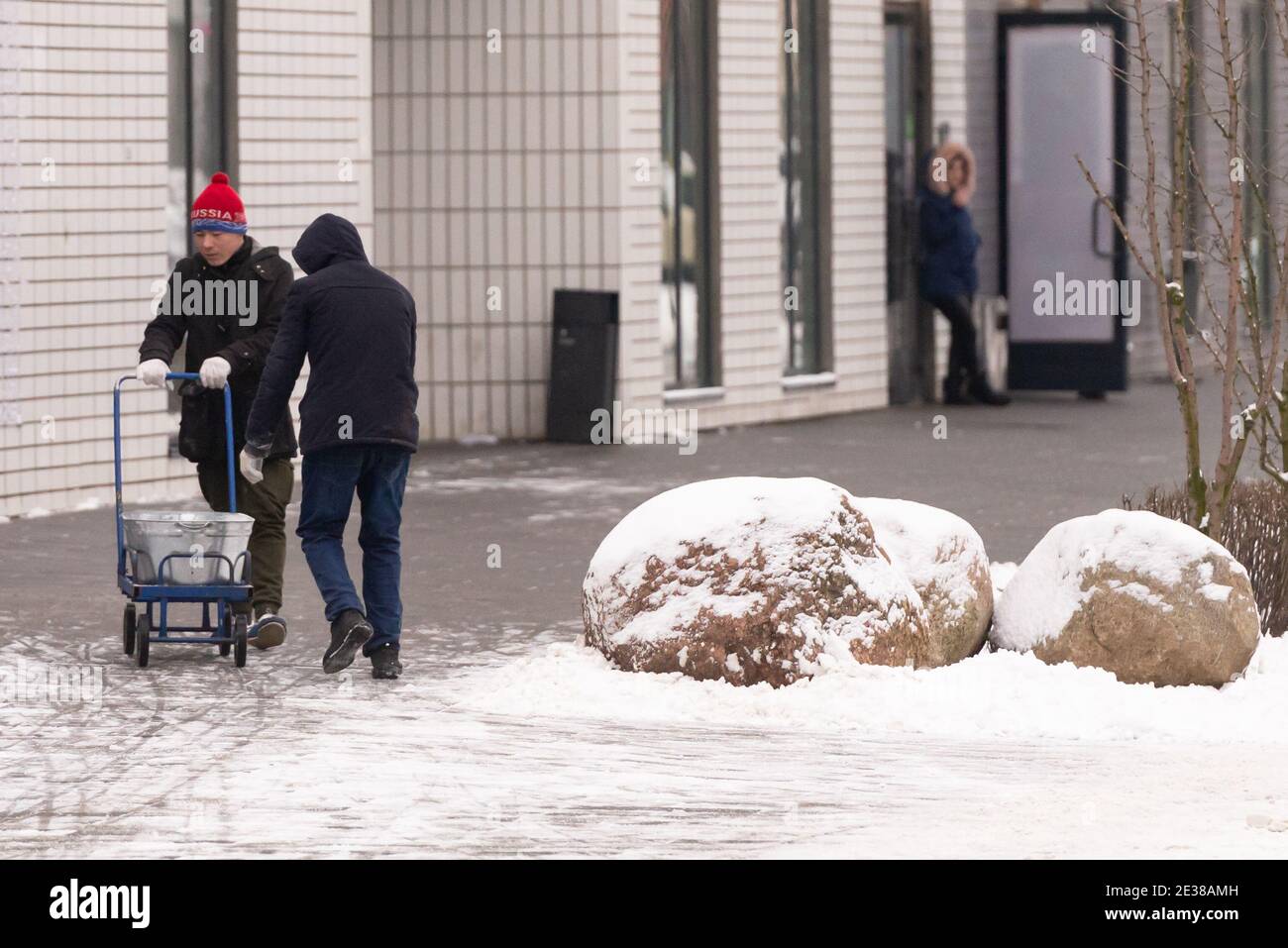 Moscow. Russia. Winter 2020. Two janitors deliver anti-ice reagents in a wheelbarrow. Stock Photo
