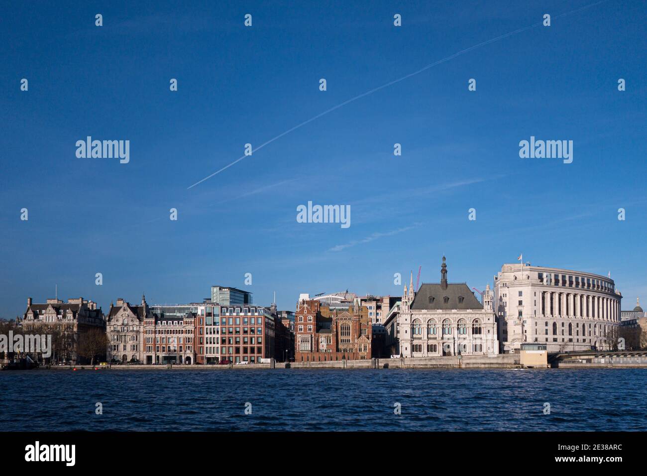 Cityscape view across River Thames of row of period architecture apartment and office buildings along Victoria Embankement in London United Kingdom Stock Photo
