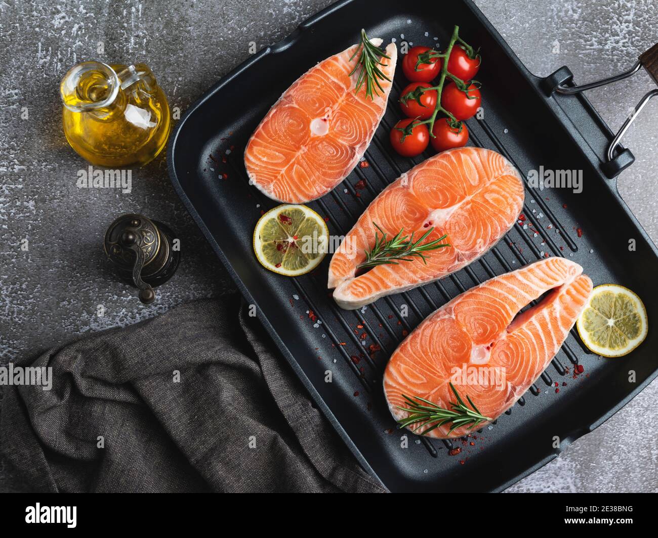 three raw steak fish trout, salmon and spices on grill pan, dark background, Stock Photo