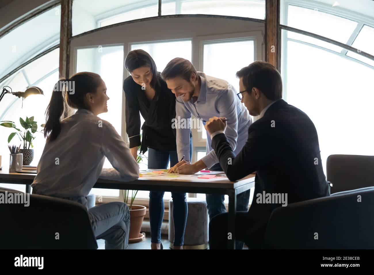 Diverse employees team working on project documents, writing notes Stock Photo