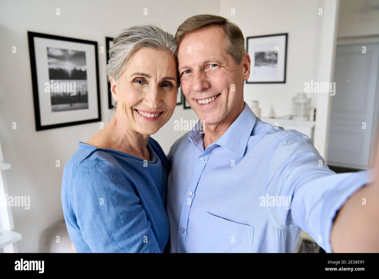 Happy senior couple looking at camera taking selfie portrait, camera view. Stock Photo