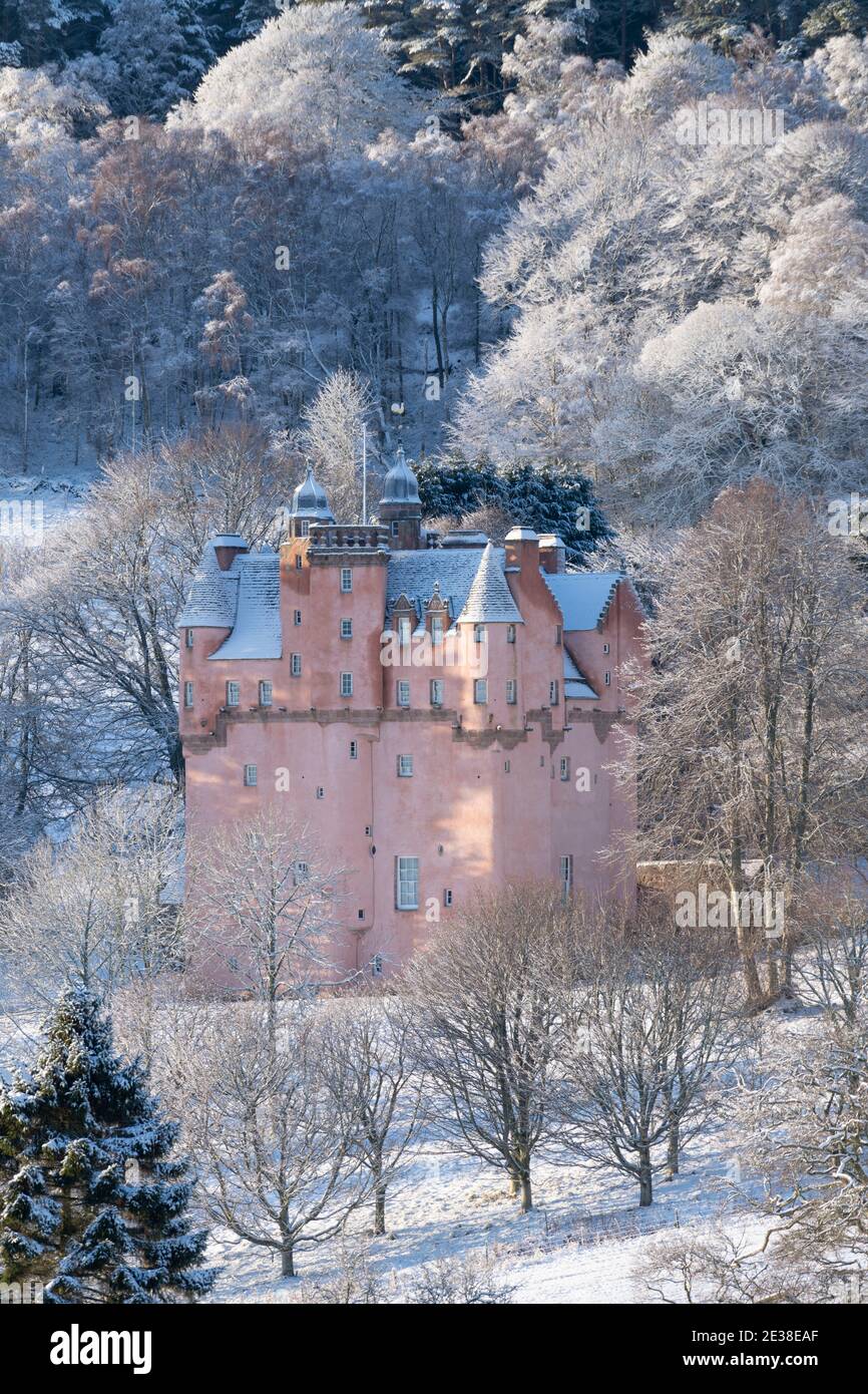 Craigievar Castle Surrounded by Woodland Trees in a Snowy Winter Landscape in Scotland Stock Photo