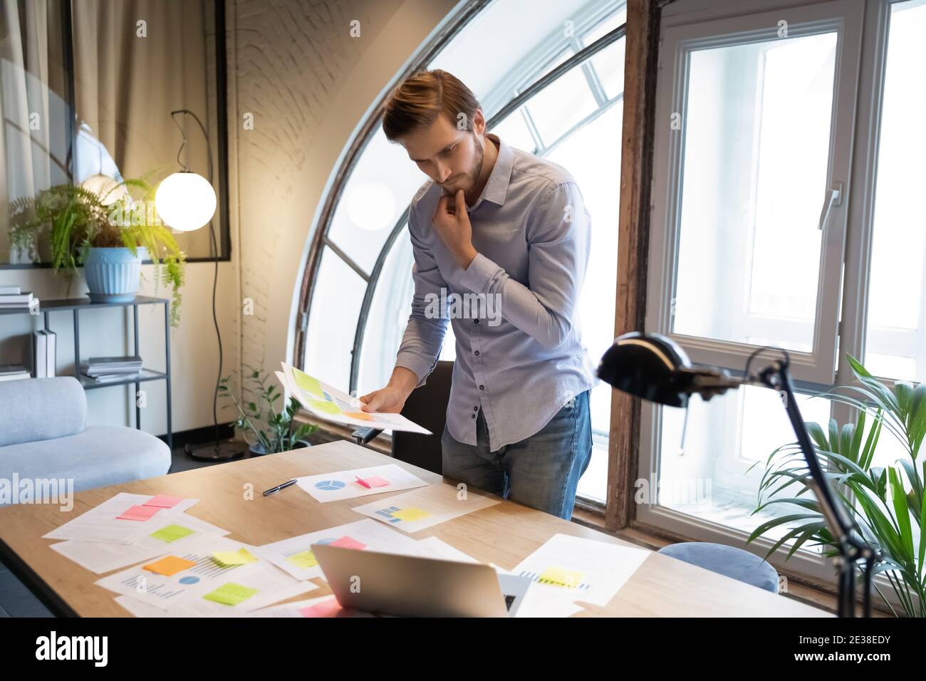 Thoughtful businessman reading documents, analyzing financial project statistics Stock Photo