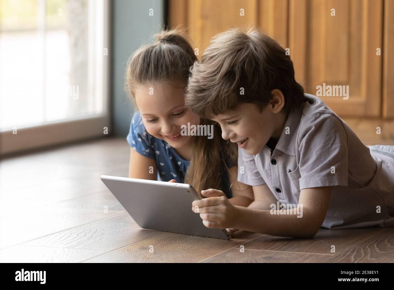 Happy little kids have fun using tablet together Stock Photo - Alamy