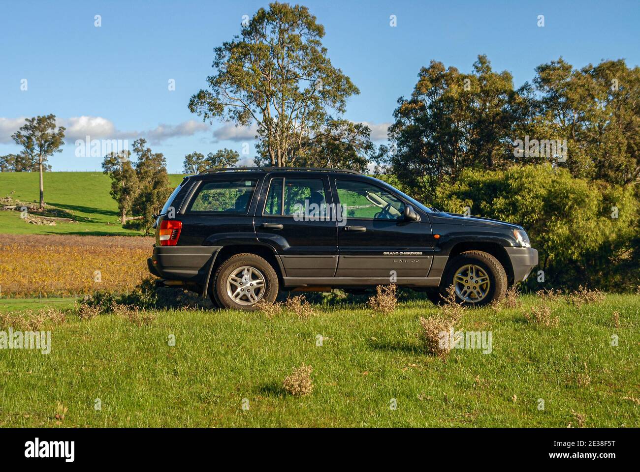 A side on view of a black 2005 Jeep Grand Cherokee Laredo, in a rural setting. Stock Photo