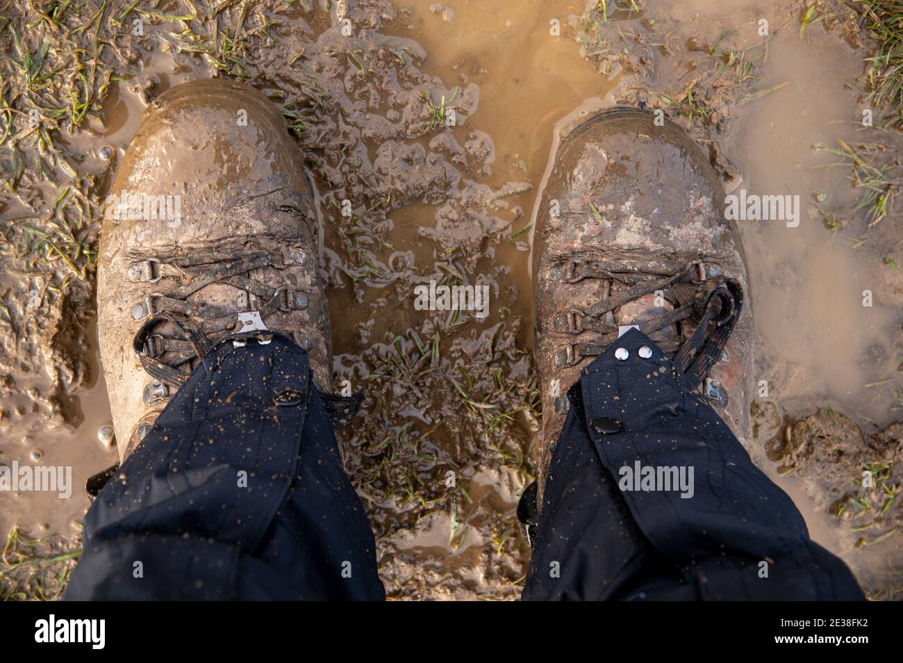 Hiking in a muddy field with boots and gaiters on Stock Photo Alamy