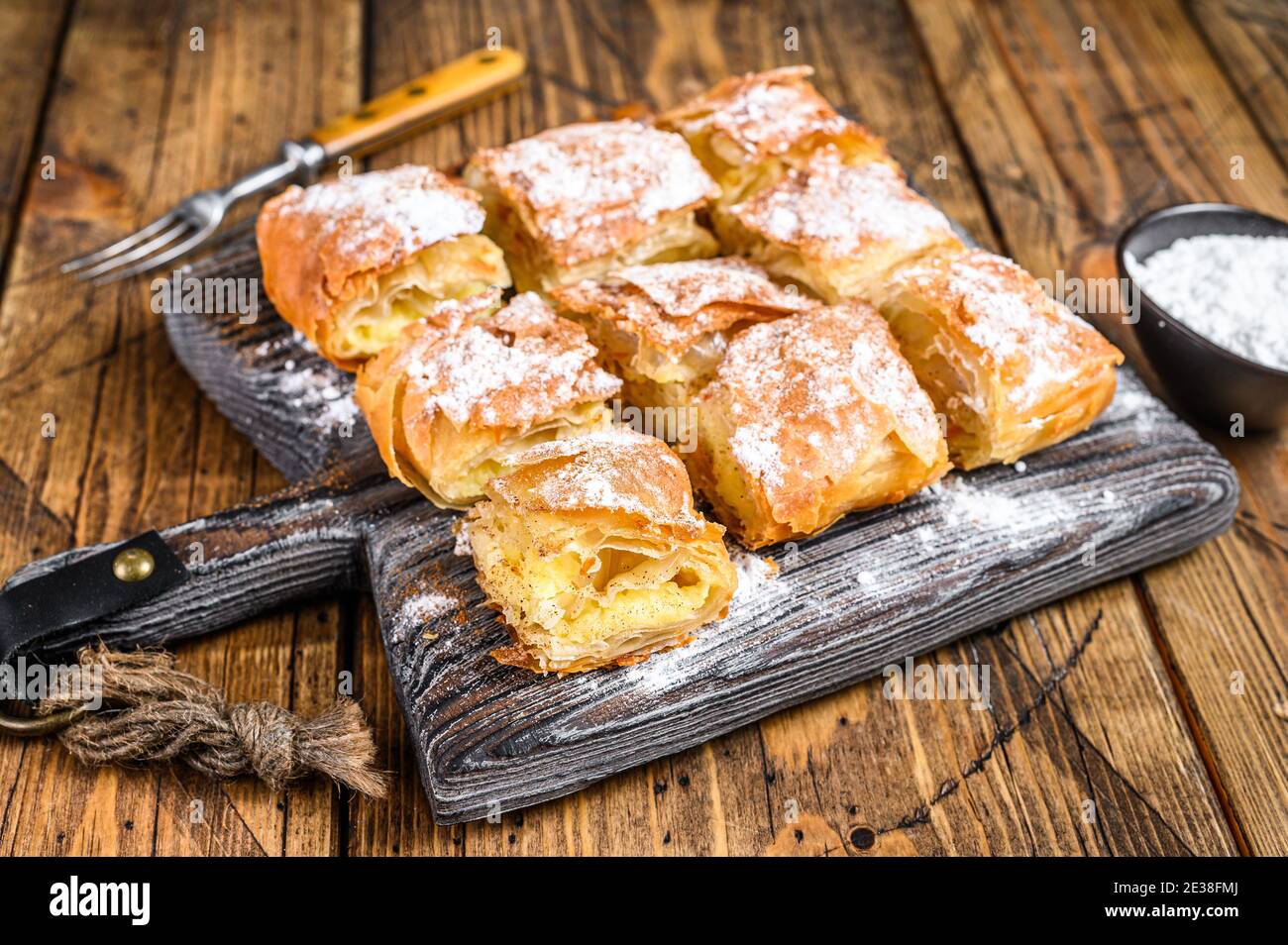 Greek pastry Bougatsa with phyllo dough and semolina custard cream. Wooden background. Top view Stock Photo