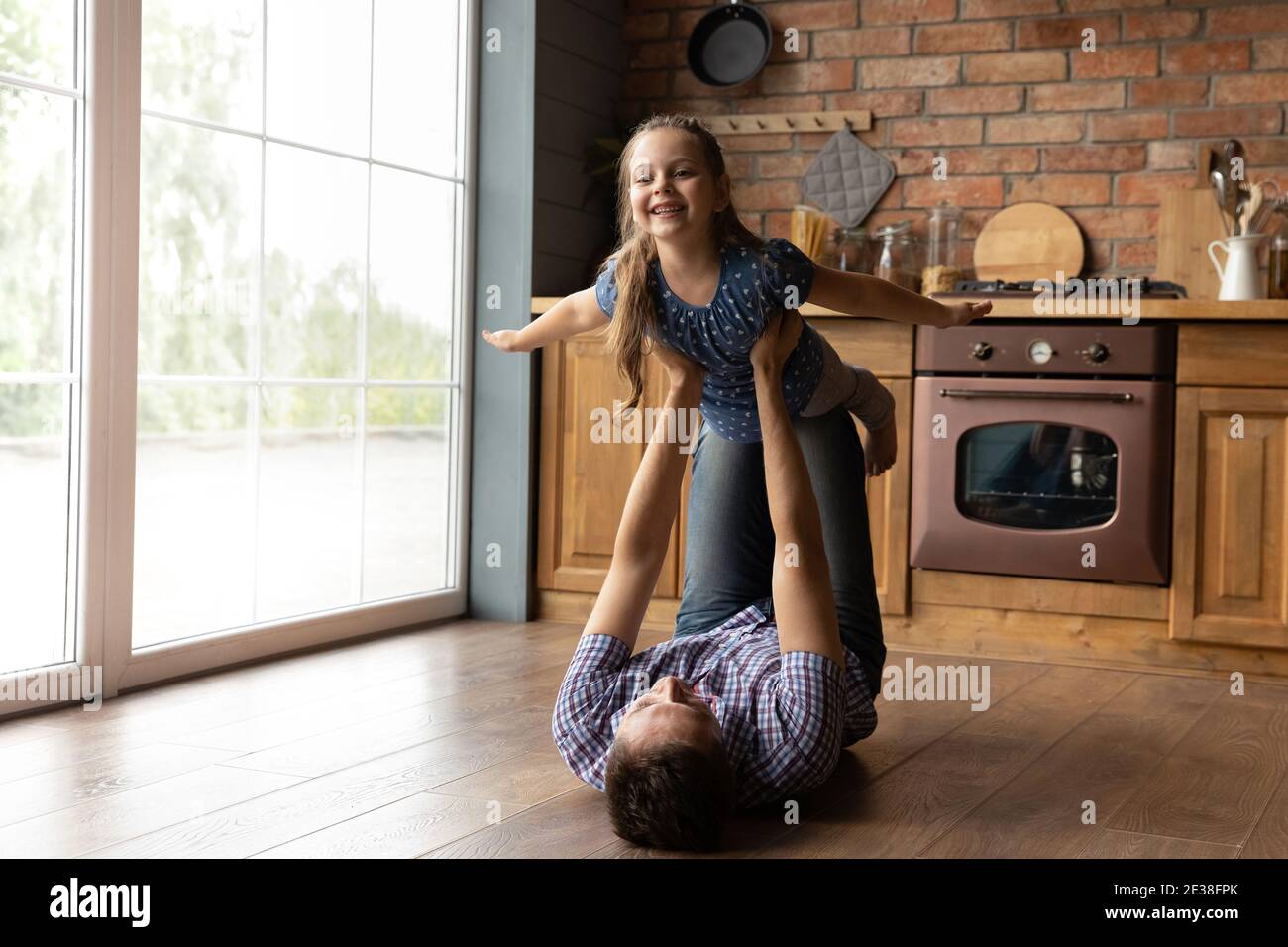Loving dad playing with excited little daughter at home Stock Photo