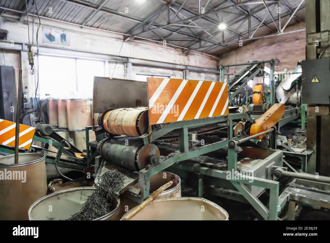 Rubber waste recycling. Industrial conveyor line with cut used car tires. Stock Photo