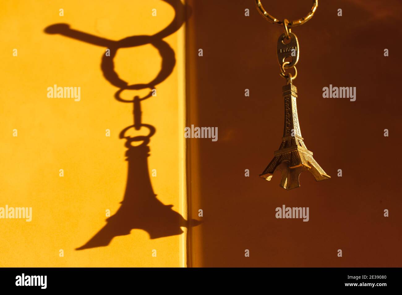 Keychain in the form of the Eiffel Tower and contrast shadow on the wall Stock Photo