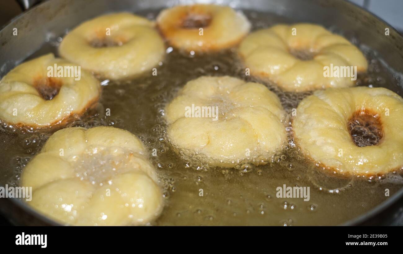 Frying cooking homemade doughnuts on hot boiling oil,fat food preparation.donuts Stock Photo