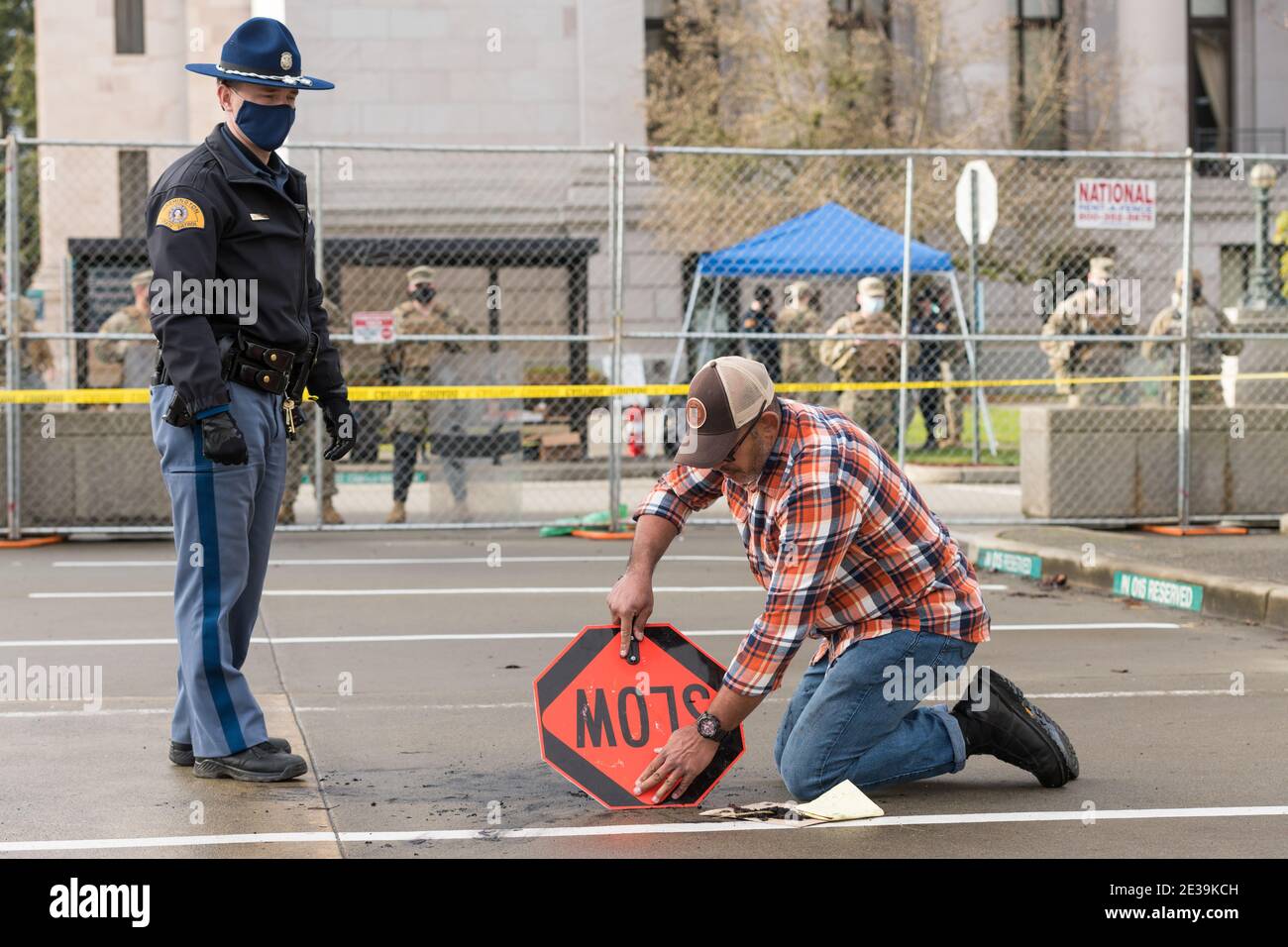 Olympia, USA. 17th Jan, 2021. Eric Pena an Air Force Veteran cleans up