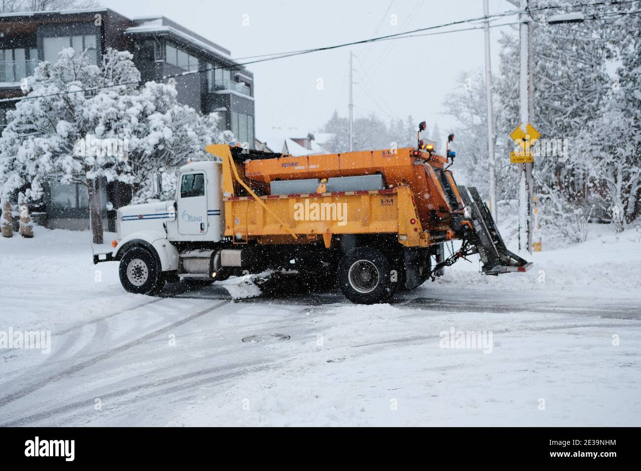 A yellow City of Ottawa snow plow truck roams the Glebe streets during