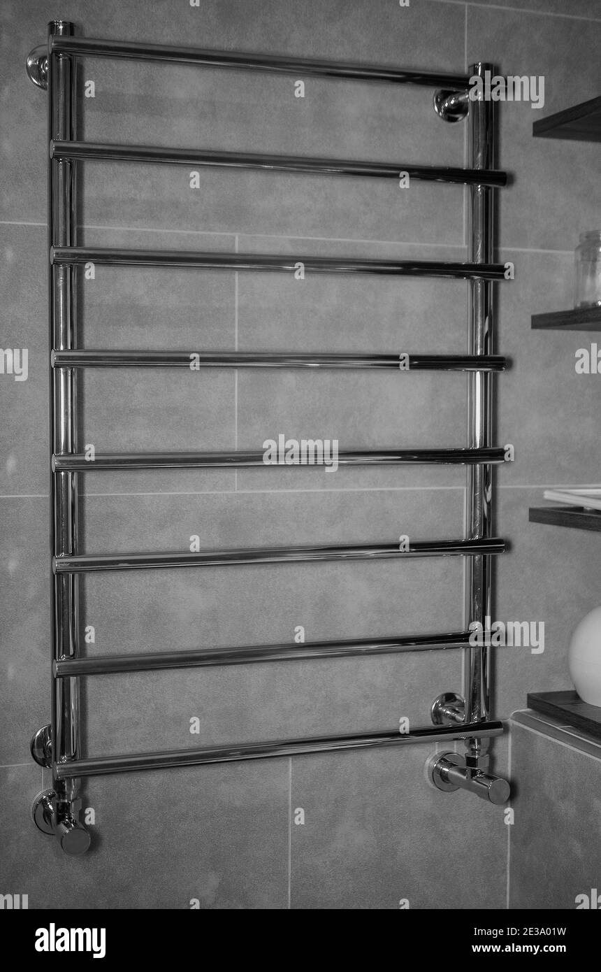 Metal heated towel rail, chrome radiator in the bathroom Stock Photo