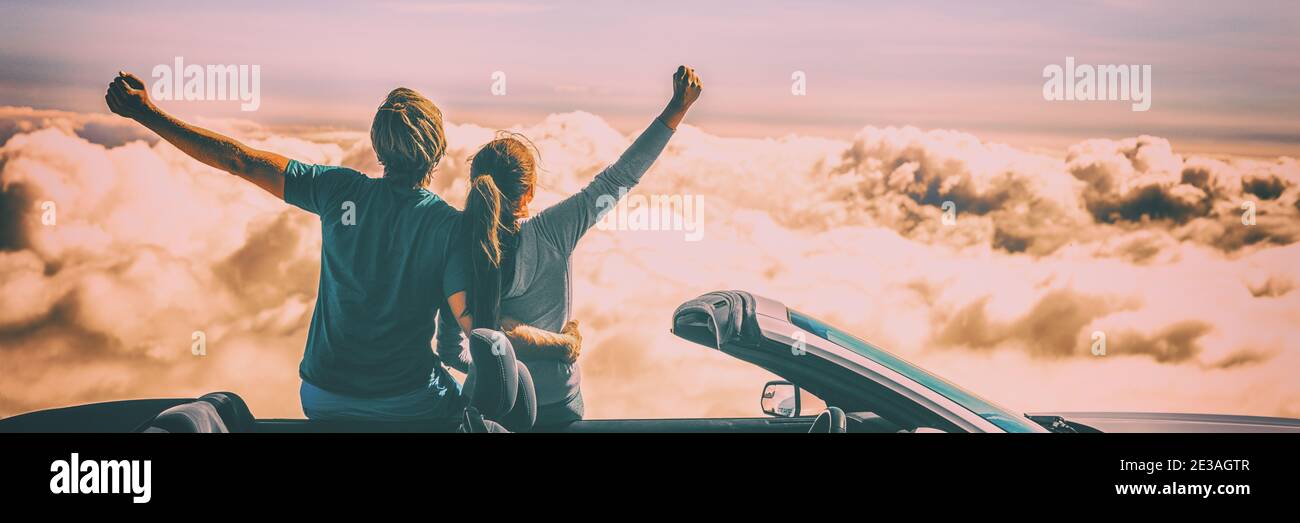 Happy car people excited with arms up on road trip. Tourists couple freedom on summer travel vacation driving convertible sports car feeling excited Stock Photo
