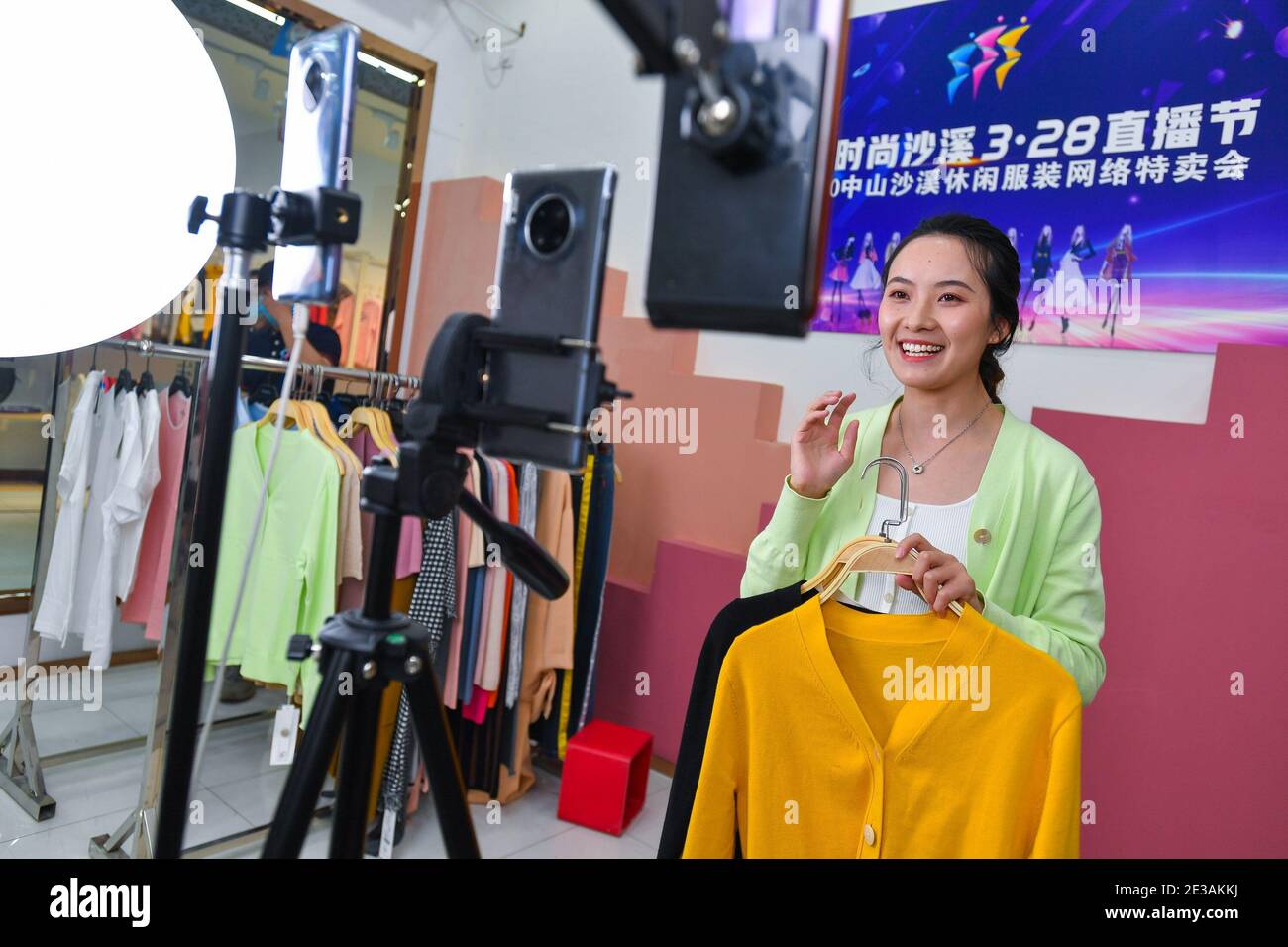 Beijing, China's Guangdong Province. 28th Mar, 2020. A woman sells clothes in front of phone cameras via livestreaming on an e-commerce platform in Shaxi Town in Zhongshan City, south China's Guangdong Province, March 28, 2020. China's gross domestic product (GDP) exceeded the 100-trillion-yuan (15.42 trillion U.S. dollars) threshold as it posted a 2.3 percent year-on-year expansion to 101.5986 trillion yuan in 2020, data from the National Bureau of Statistics showed Monday. Credit: Liu Dawei/Xinhua/Alamy Live News Stock Photo