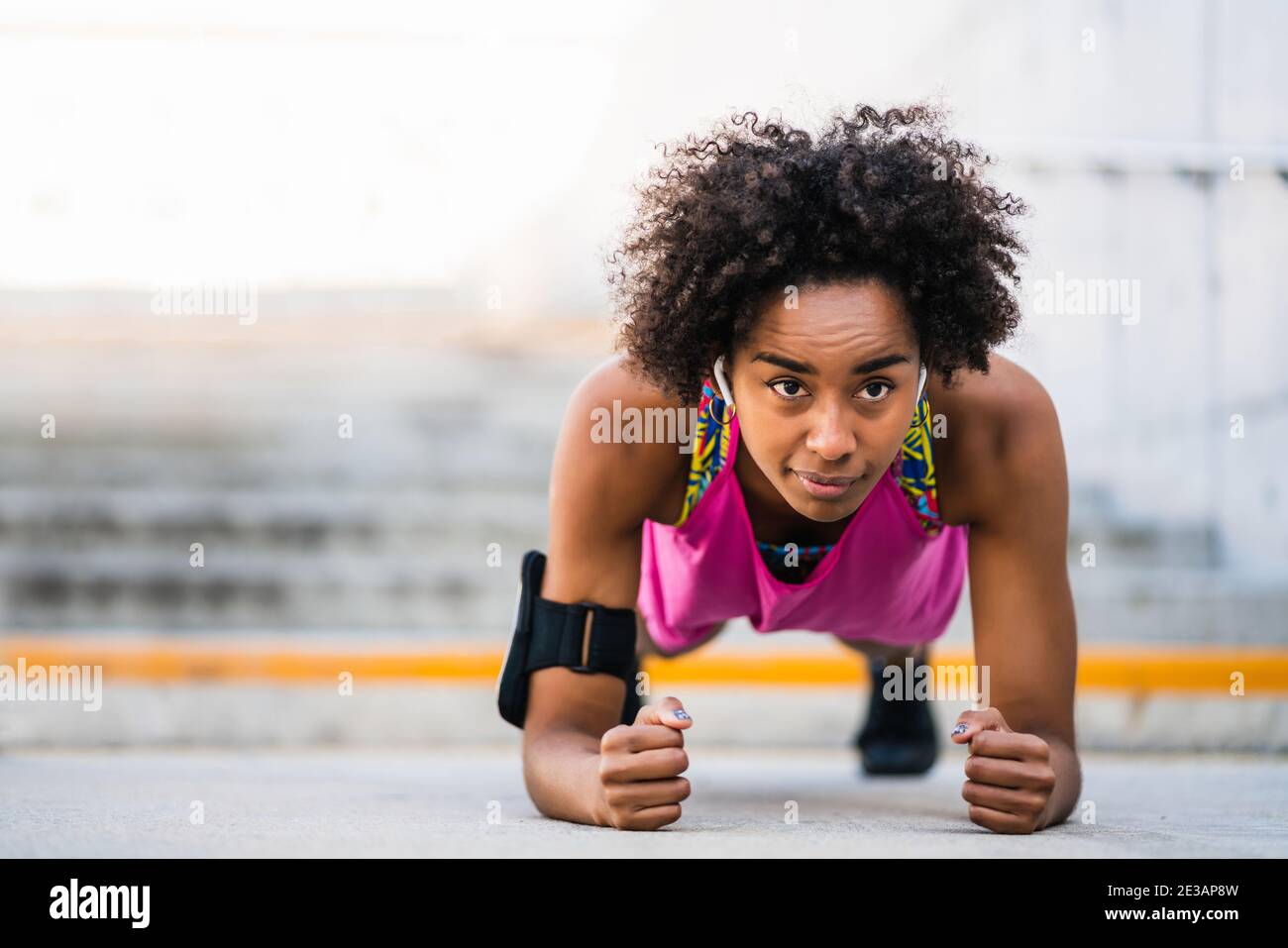 Afro athlete woman doing pushups outdoors. Stock Photo