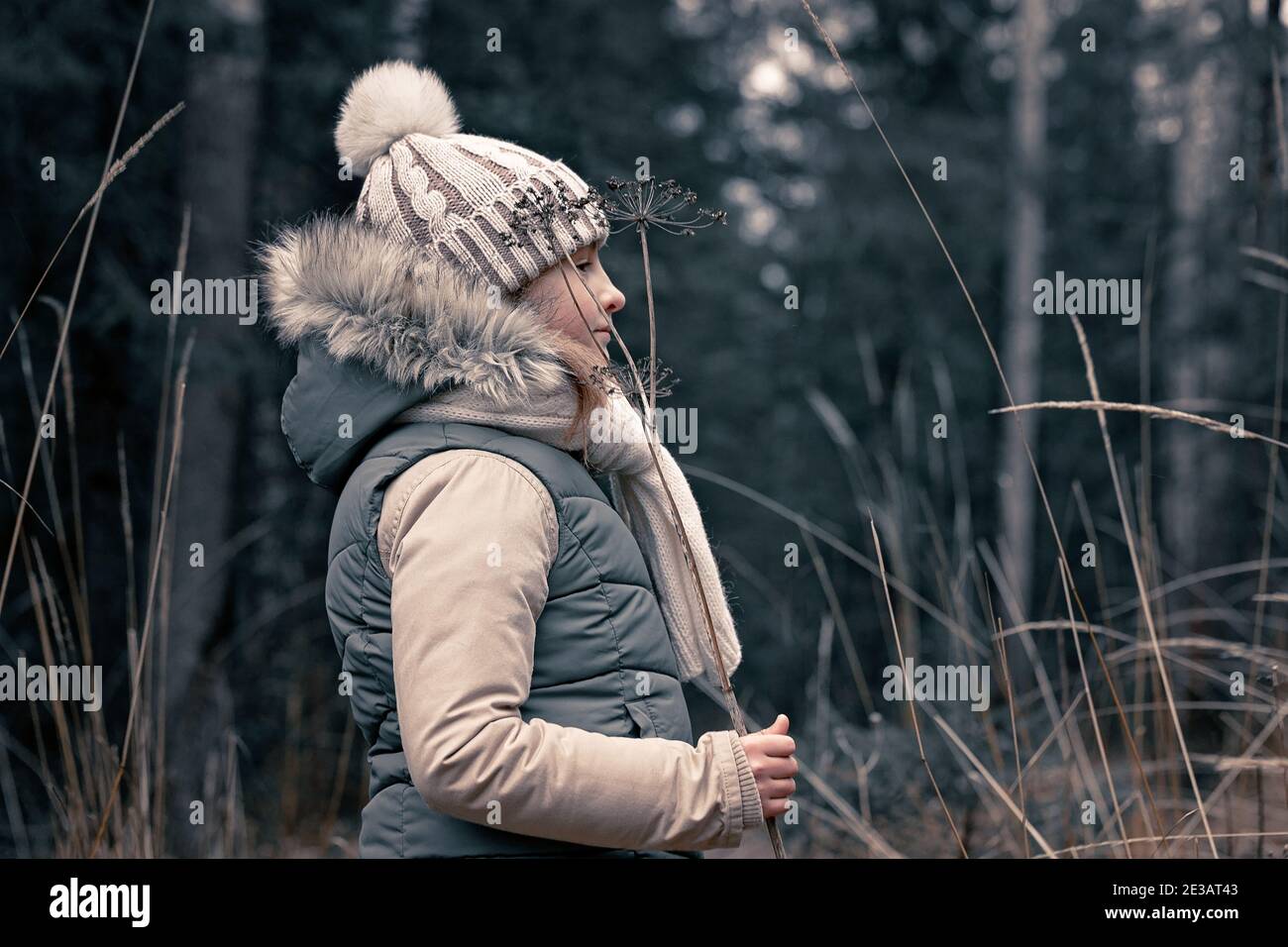 Cute teenage girl in a warm hat and scarf on the background of a