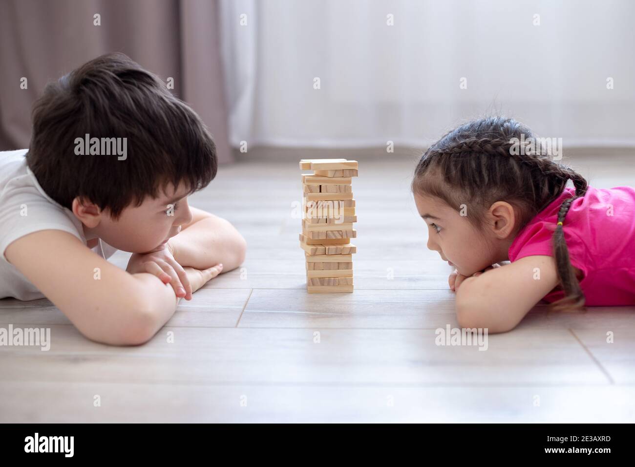 Two children playing wooden game on the floor Stock Photo Alamy