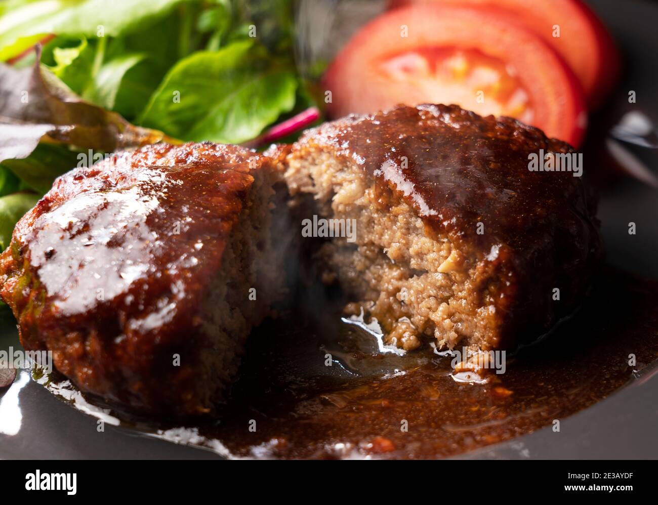 Cross section of hamburger with demi-glace sauce cut in half Stock Photo