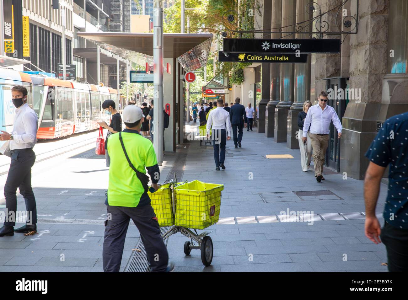 Australia Post employee postman with mail delivery trolley delivering
