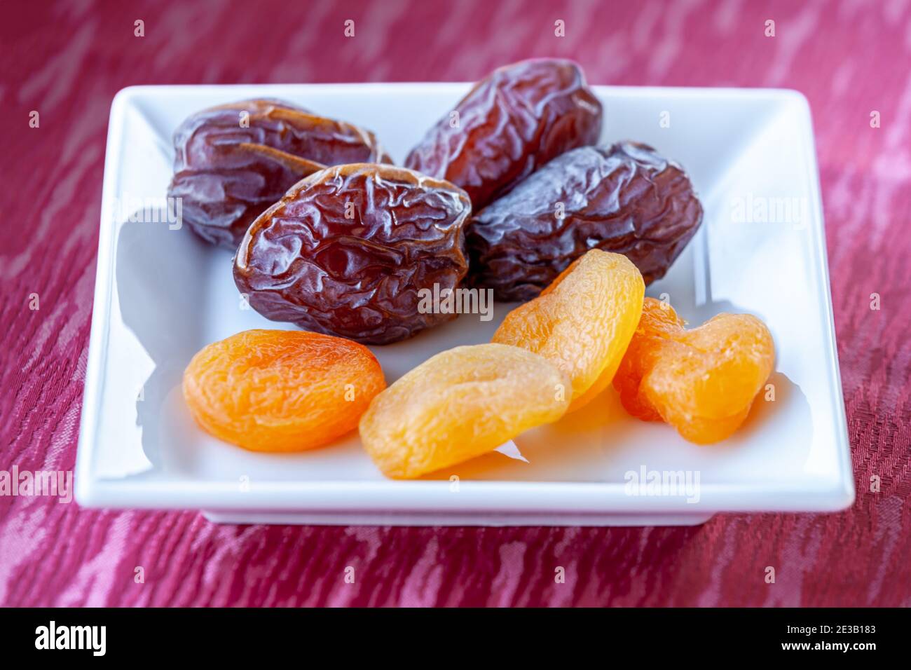 Plenty of dates and apricot arranged in a white bowl Stock Photo