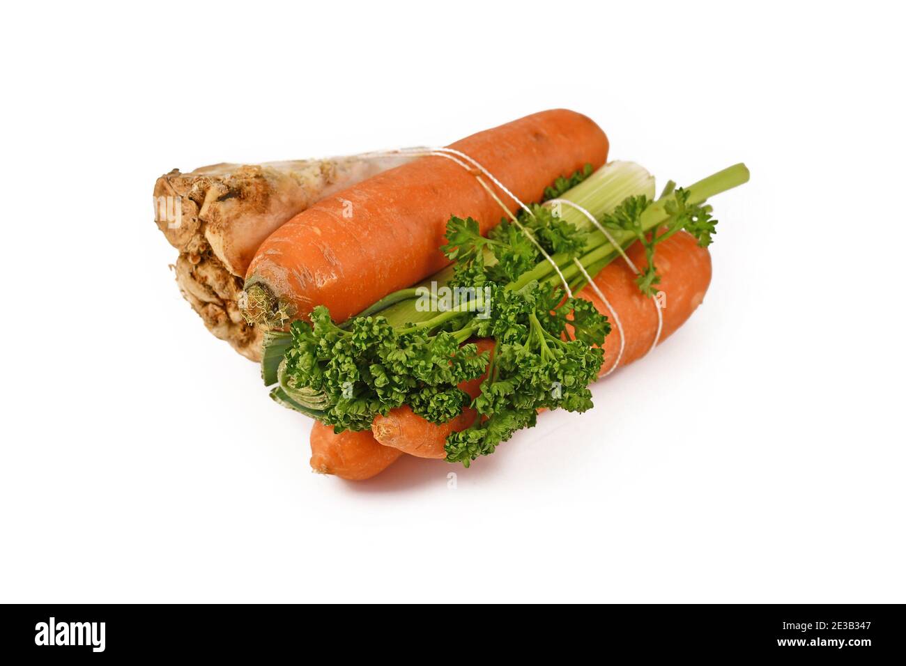 Bundle of soup vegetables containing carrots, leeks, parsley and celery root isolated on white background. Traditionally sold at German supermarkets Stock Photo