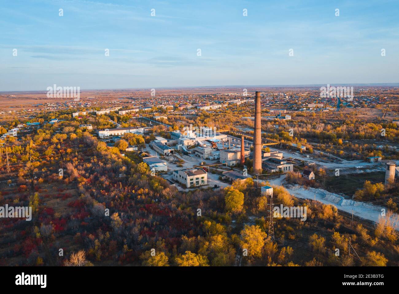 Old manufacturing factory with high funnel pipe, aerial view Stock Photo