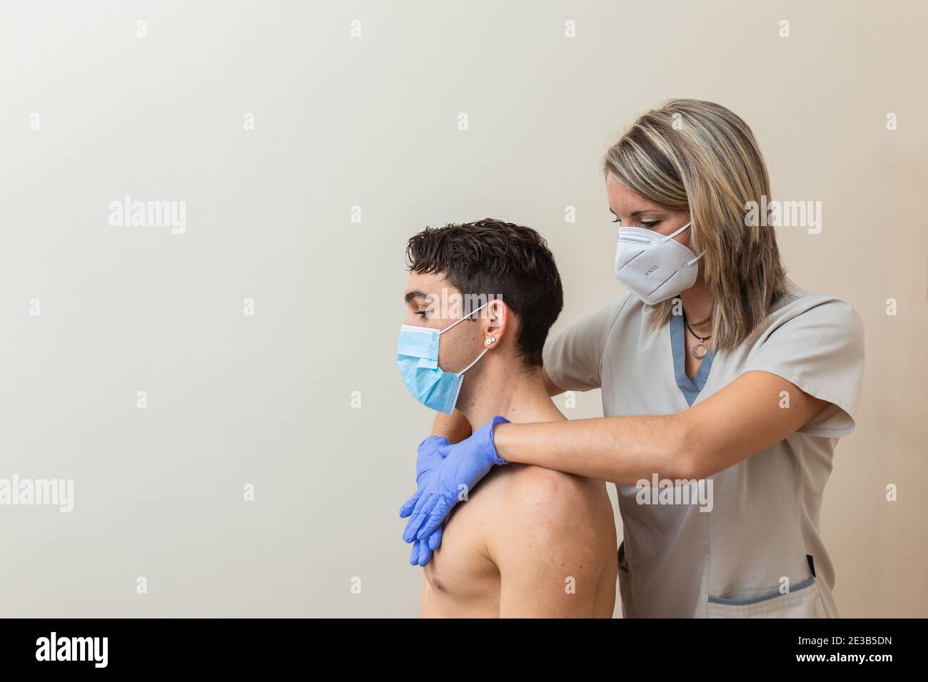 woman physiotherapist with mask does massage. Cervical manipulation