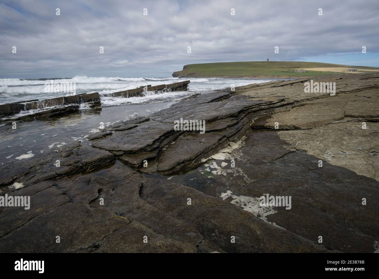 View of waves breaking on Marwick Bay on the west coast of Orkney, looking towards the Kitchener Memorial on Marwick Head Stock Photo