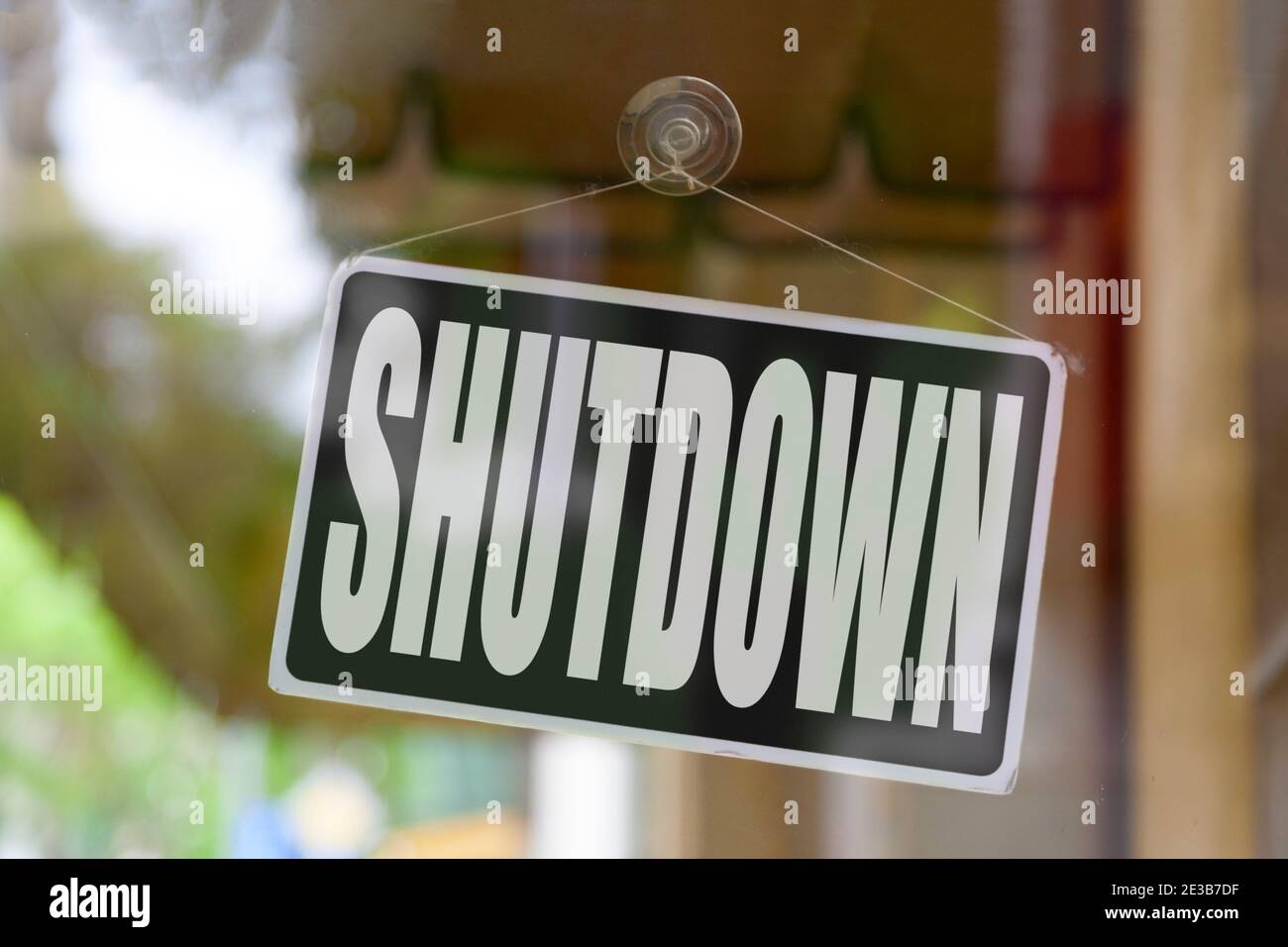Close-up on a red open sign in the window of a shop displaying the message: Shutdown. Stock Photo