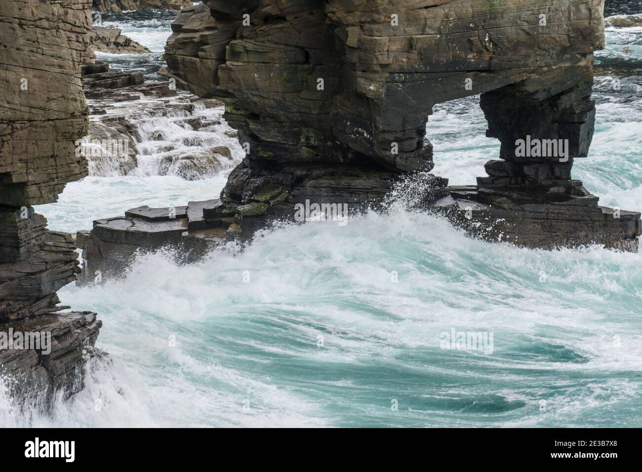 Waves crashing against the base of Yesnaby Castle, a famous sea stack in Sandwick, Orkney, Scotland Stock Photo