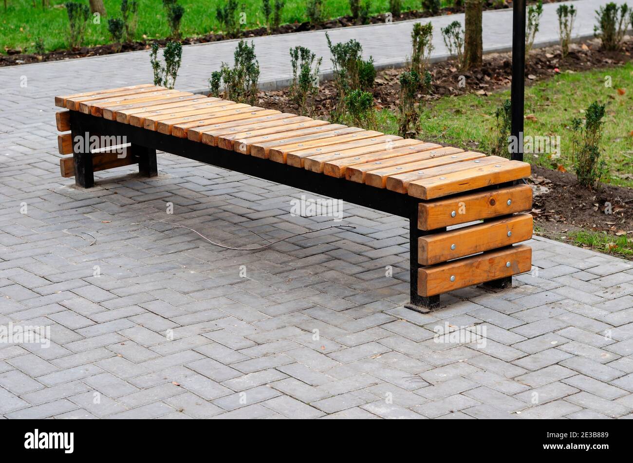mengen Explosieven Smerig Creative empty wooden park bench. U-shaped bench made of metal and wooden  bars. Modern urban lifestyle Stock Photo - Alamy