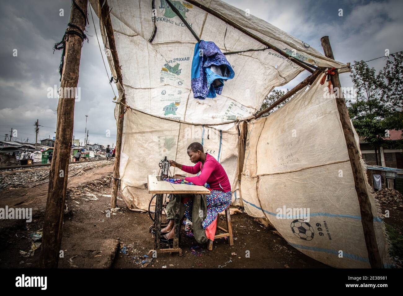 Textile Slum A woman is seen working inside her small tailoring shop made with ...