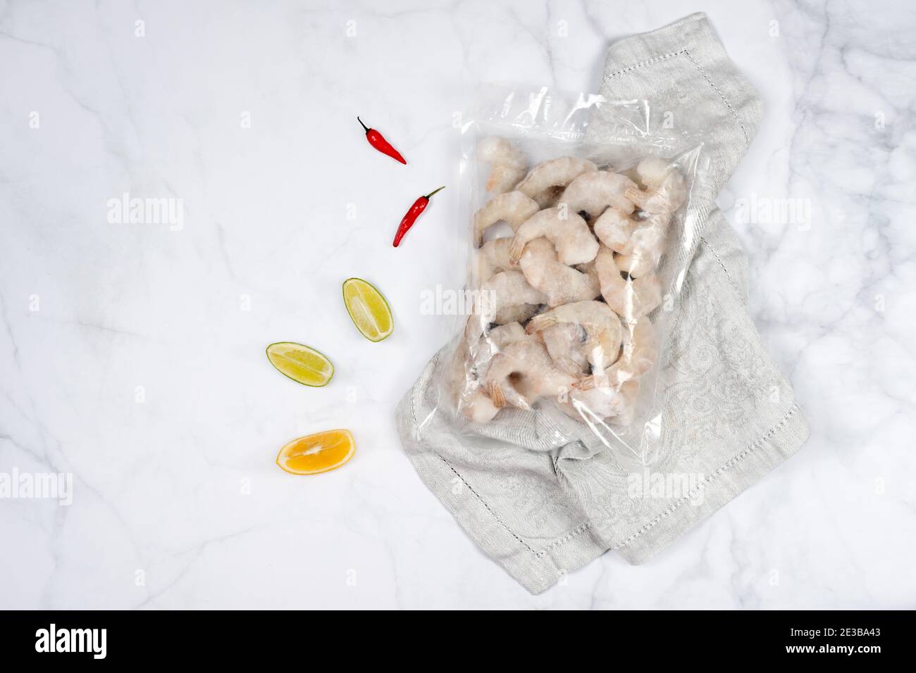 Products in vacuum packaging on wooden board. Frozen shrimps, vacuum