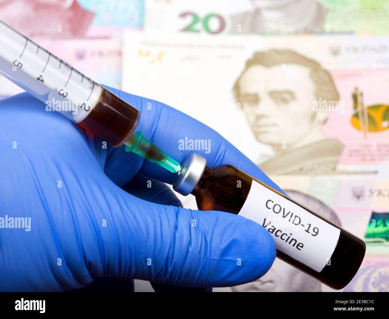 Vaccine against Covid-19 on the background of Ukrainian money Stock Photo