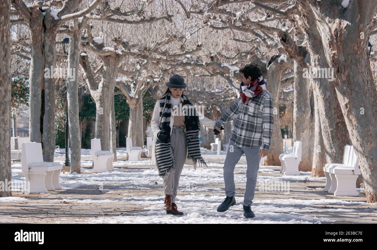Horizontal photography of a young couple walking on a winter day in Spain after it has snowed. Winter Day Concept 2021. Stock Photo