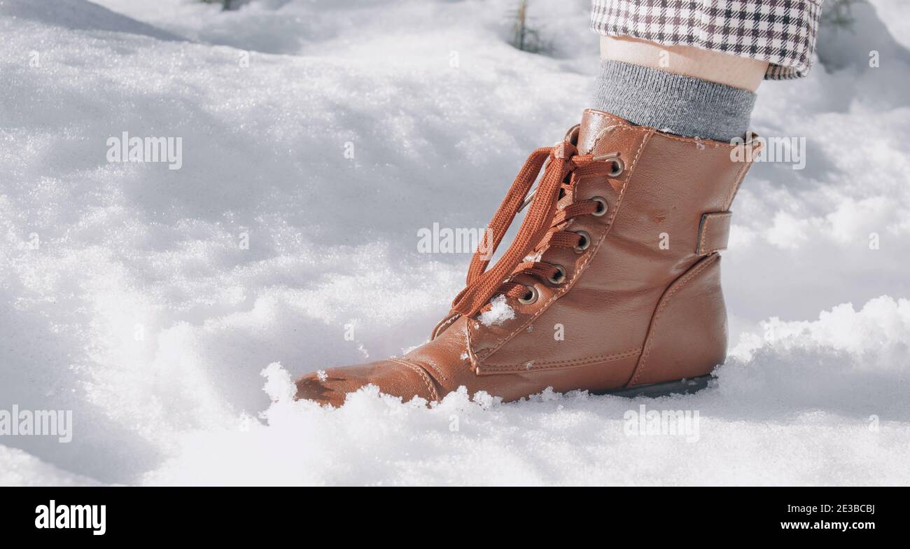 Personal view of a female foot in brown boots, winter walking in snow. Beautiful white winter weather with fresh snowfall. Winter Photography 2021. Stock Photo