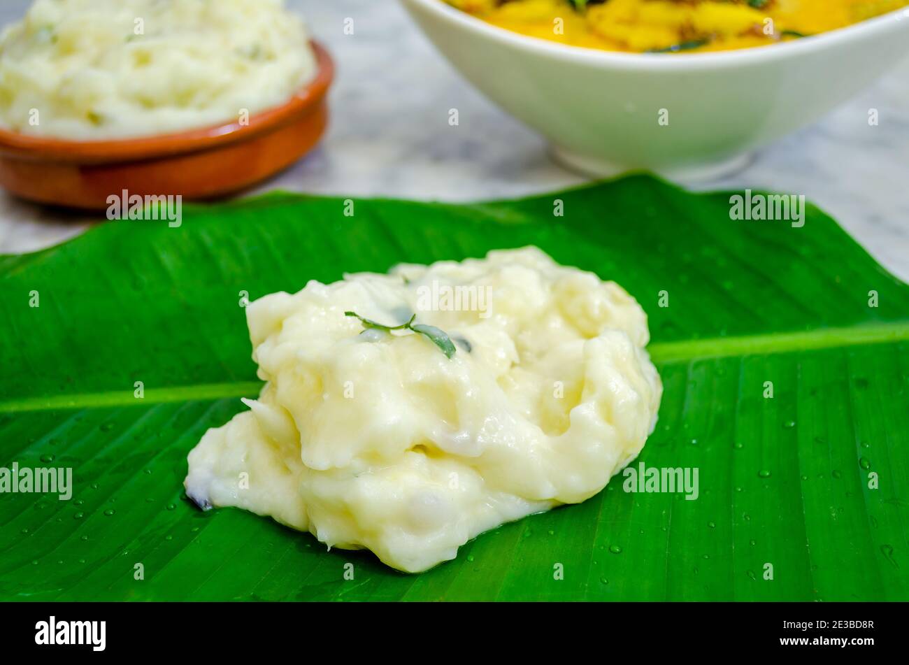 Closeup of tapioca cooked in coconut milk on a banana leaf with fish curry and more tapioca (Pal Kappa) Stock Photo