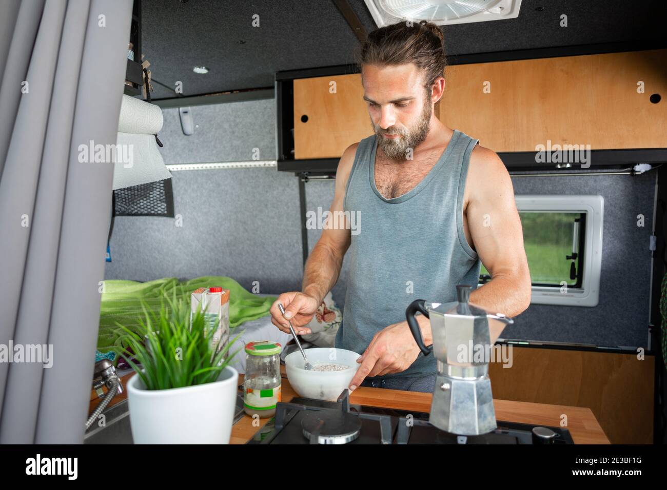 Man preparing cereal inside a camper van Stock Photo