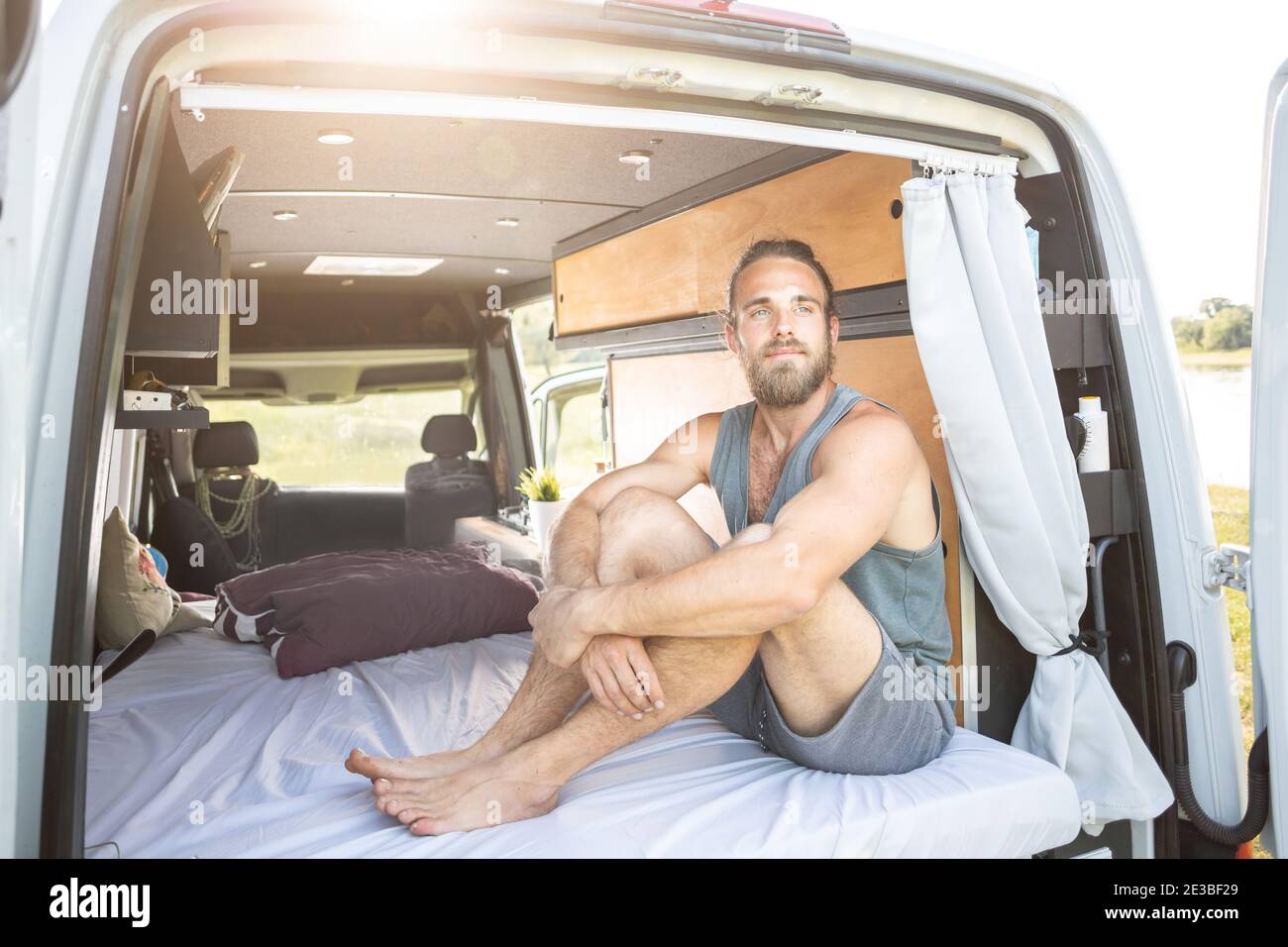 Young man in the back of his camper van Stock Photo
