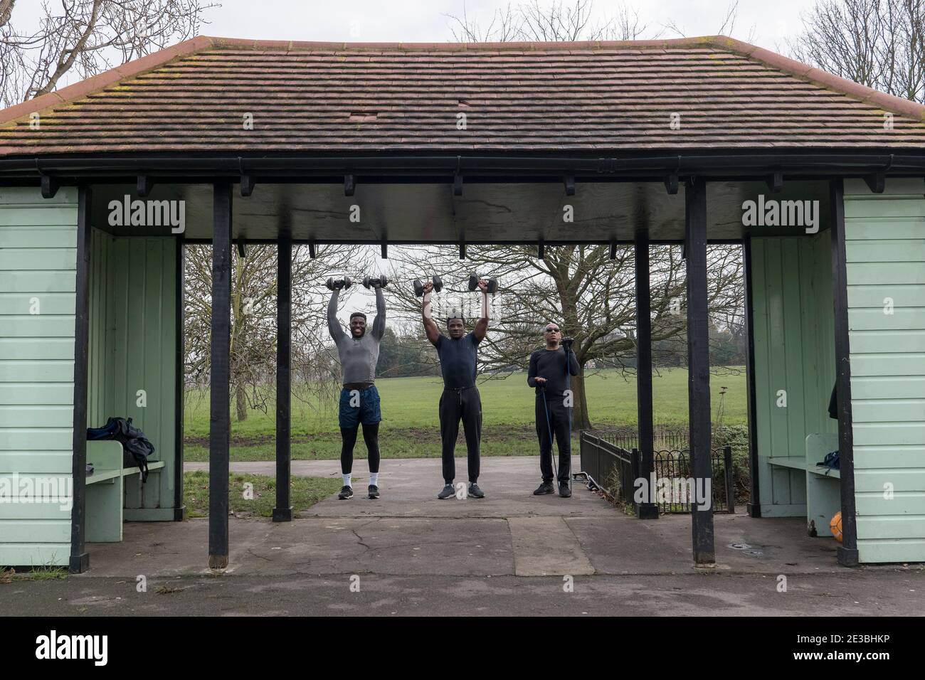 Men lifting weights during a fitness training session in Brockwell Park