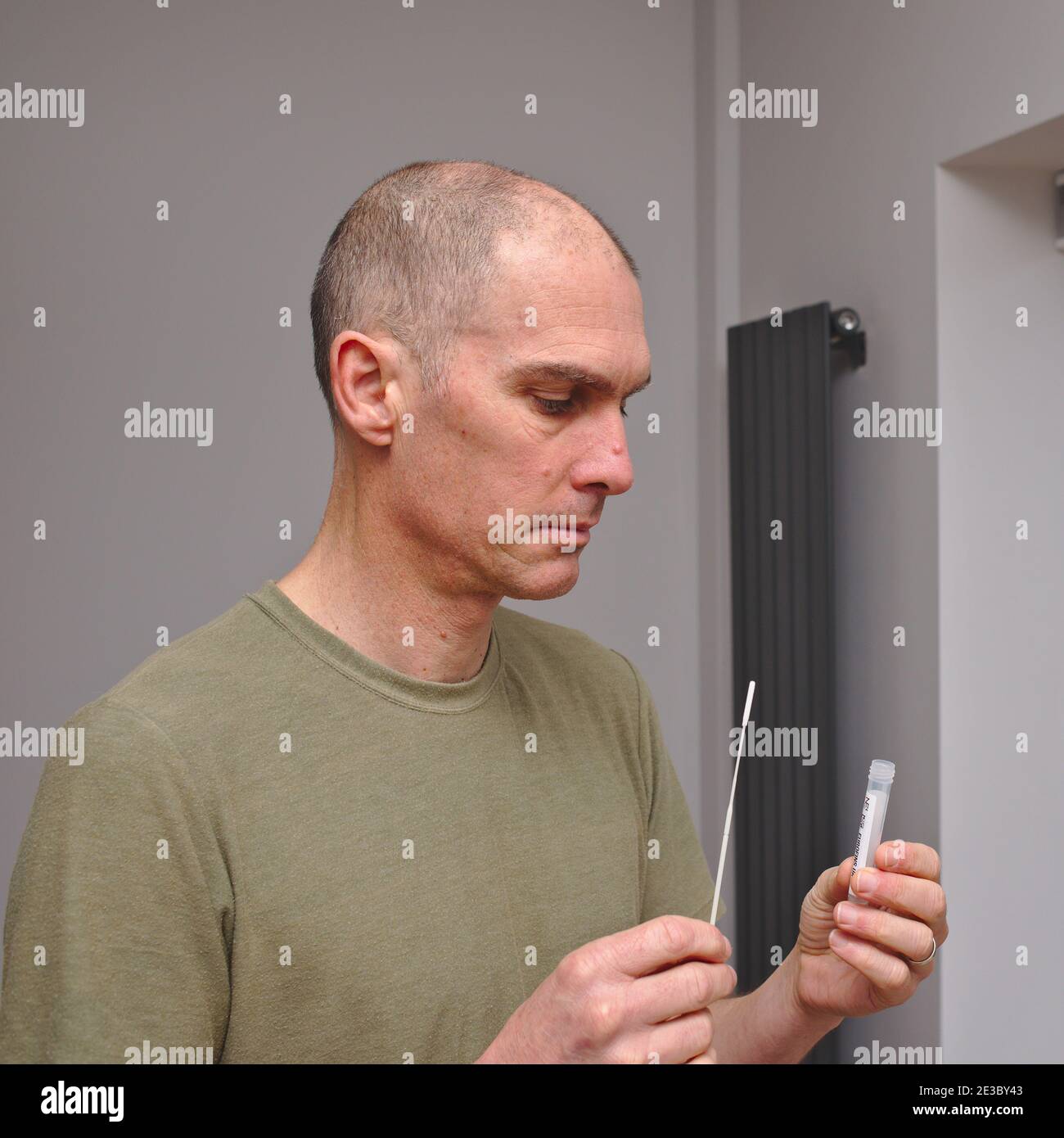 Man taking part in covid 19 research study uses a home testing kit supplied by the NHS and Ipsos MORI to help monitor the prevalence of coronavirus. Stock Photo