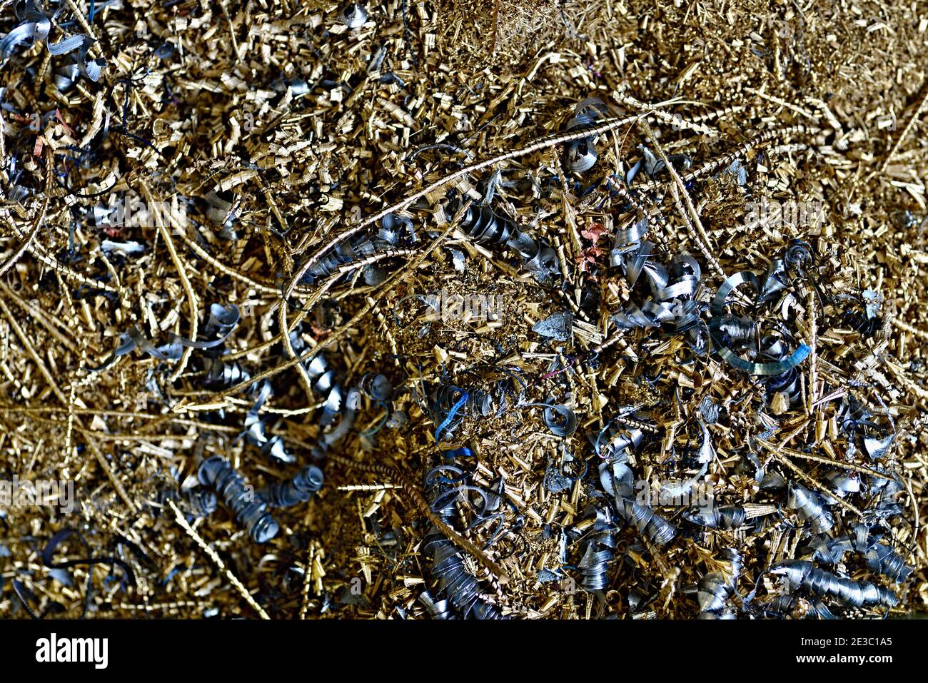 Copper, brass and steel chips in the machine shop. A pile of metal chips at a working machine. Stock Photo