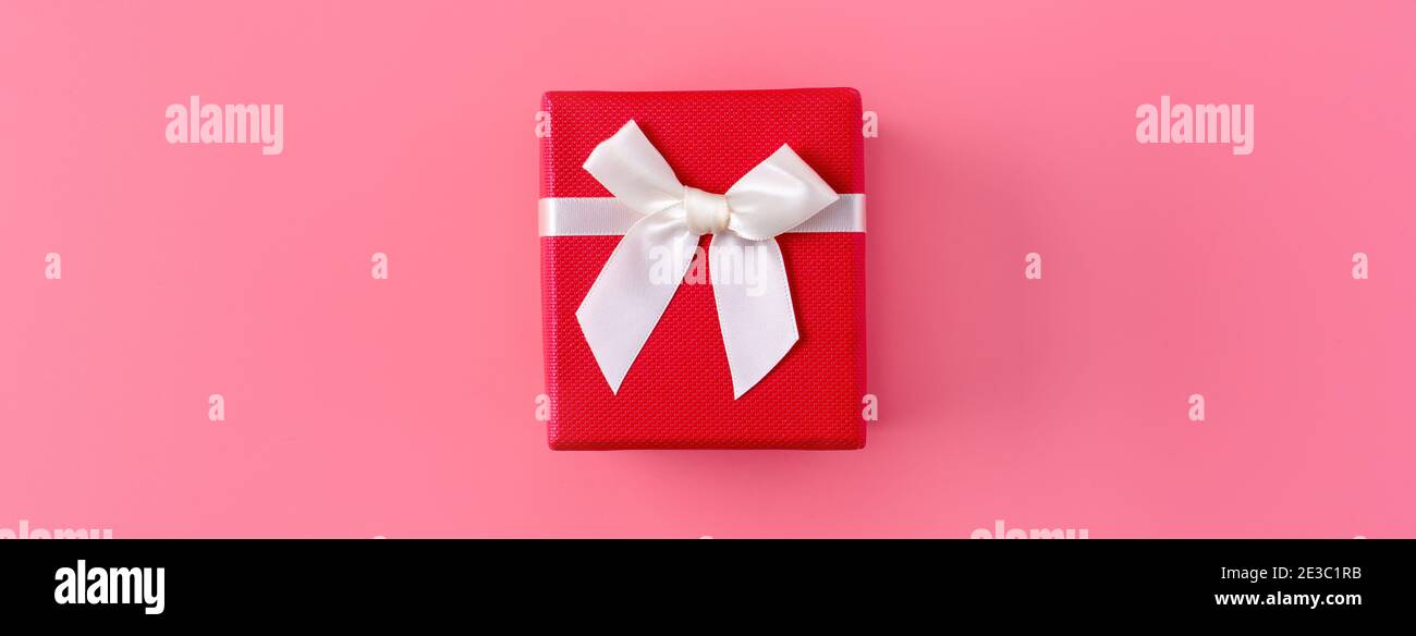 Beautiful gift box wrapped with ribbon bow on pastel pink background ...