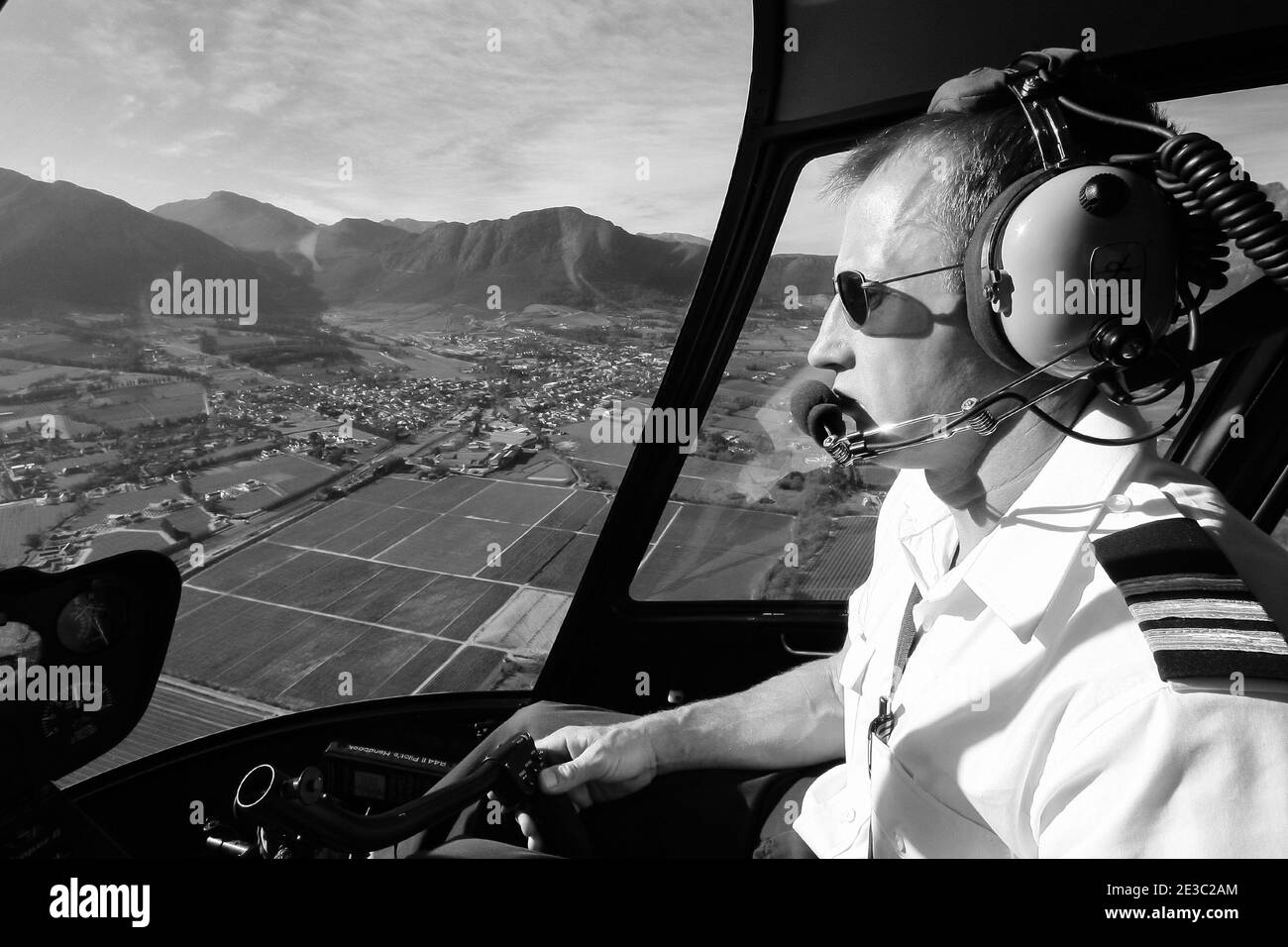 CAPE TOWN, SOUTH AFRICA - Jan 06, 2021: Hermanus, South Africa - July 20, 2009: Caucasian male helicopter pilot flying a R44 type chopper over rural a Stock Photo