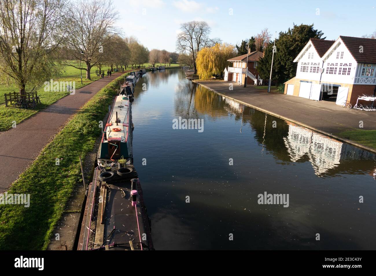 Boathouses and moored narrow boats on the River Cam on a calm autumn day Cambridge England Stock Photo