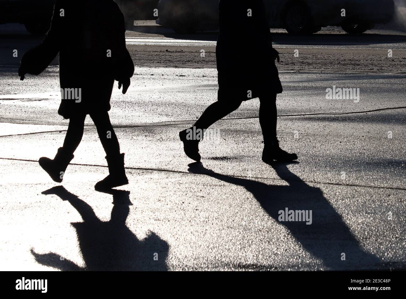 Black silhouettes and shadow of people walking down on a city street on cars background. Concept of hurrying pedestrians, population Stock Photo