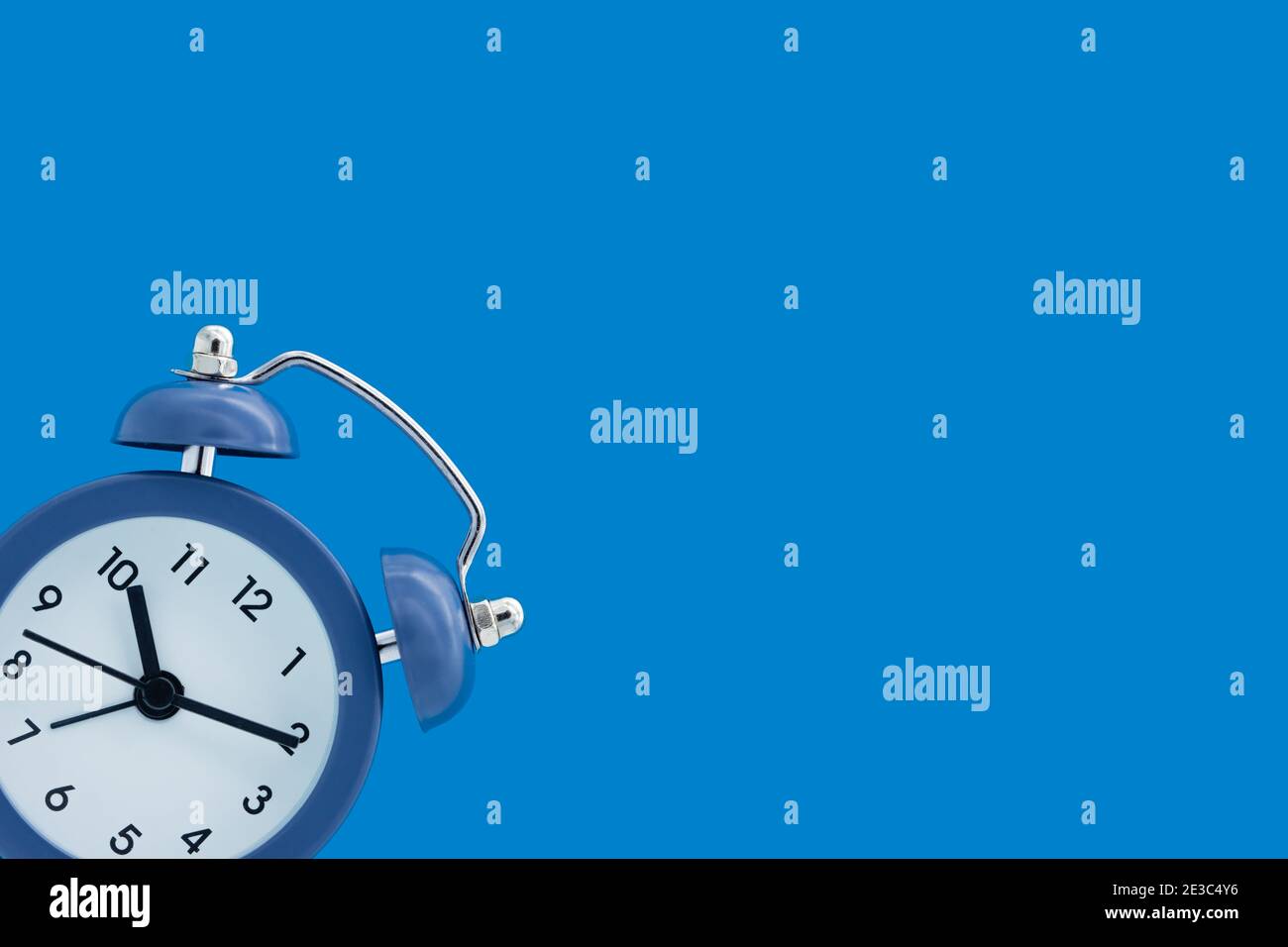 Classic alarm clock isolated on blue background Stock Photo - Alamy